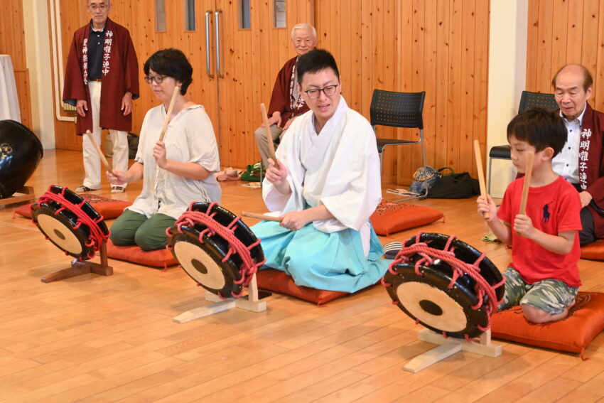 荒井さん（前列中央）の指導でまつり囃子を練習する参加者たち