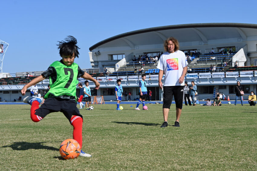 岡野選手（右）らの指導でサッカーを練習する子ど