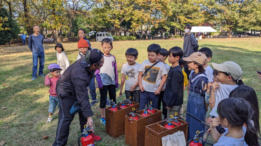 消防団員から消火器の使い方を教えてもらう子どもたち